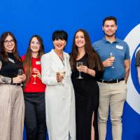 President Mantella standing with 6 other Lakers standing in front of blue backdrop with white Circle G on it.